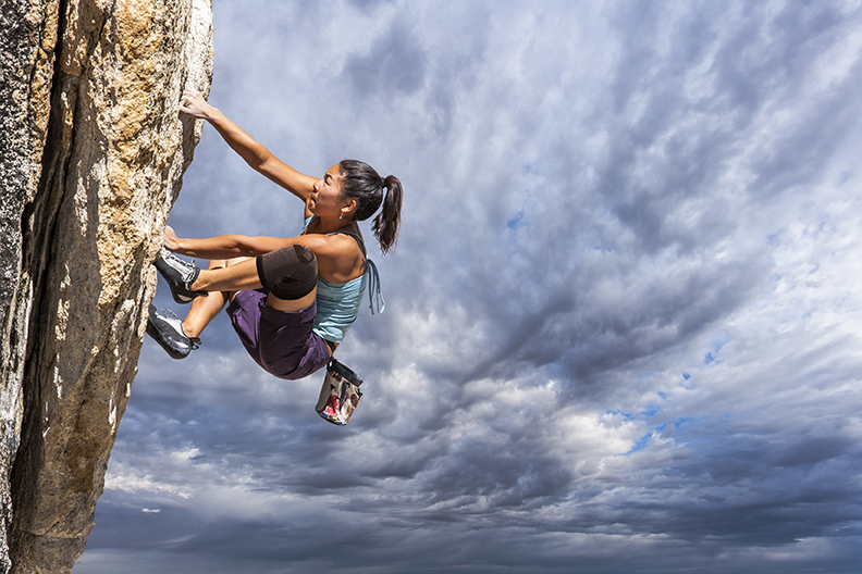 Rock climber clinging to a cliff.
